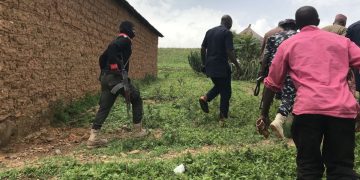 Police and young adults patrol Funzai village in Mangu County, Plateau State, Nigeria, on May 17 after 50 residents were killed the previous day.