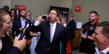 Florida Gov. Ron DeSantis enjoys a beer with supporters Friday after a speech in Iowa.