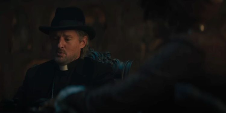 In this screenshot from the new “Haunted Mansion” trailer, Owen Wilson, who plays Father Kent in the movie, is seen in conversation with another character.