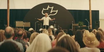 In this frame of "Jesus Revolution," actor Kelsey Grammer, who plays Pastor Chuck Smith, is seen preaching.