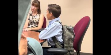 An official with the Vanguard School in Colorado Springs, Colorado, talks to 12-year-old Jaiden and his mother about his removal from class for having the Gadsden flag on his backpack.