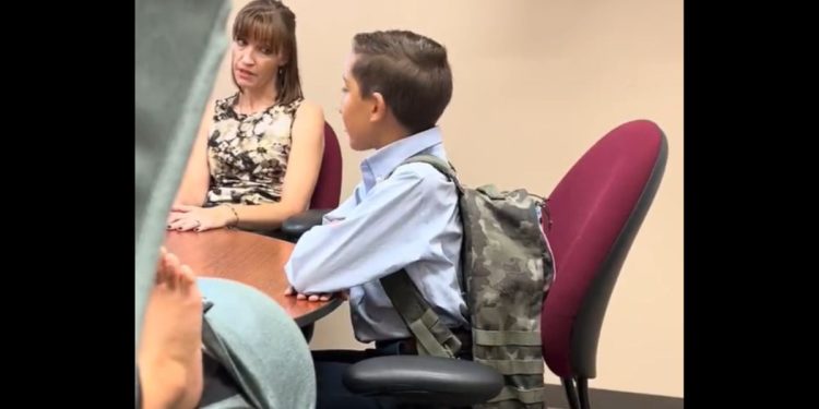 An official with the Vanguard School in Colorado Springs, Colorado, talks to 12-year-old Jaiden and his mother about his removal from class for having the Gadsden flag on his backpack.