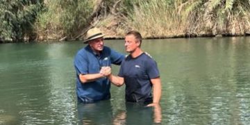Survivalist and TV star Bear Grylls is baptized in the Jordan River.