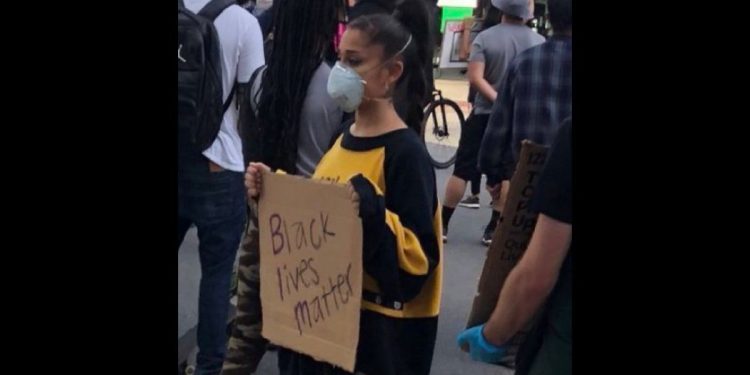 Singer Ariana Grande holds a BLM sign.