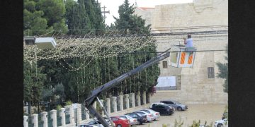 A worker takes down Christmas decorations in Bethlehem.