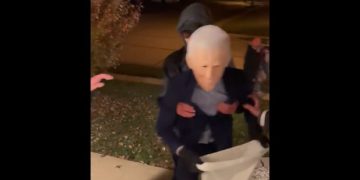 A kid in a Joe Biden costume stumbles up some stairs on Halloween.