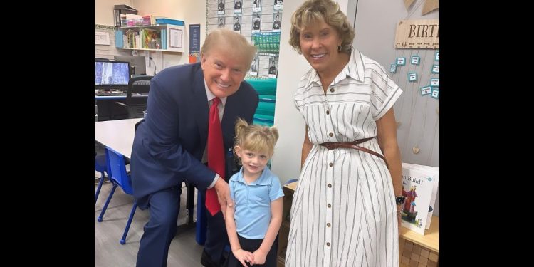Former President Donald Trump poses with his granddaughter Caroline at her school.