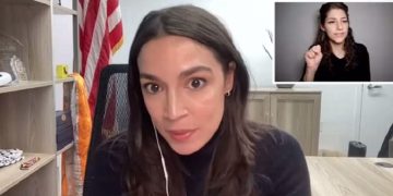 Rep. Alexandria Ocasio-Cortes is pictured in a virtual town-hall meeting on Monday. In the background is a sign language interpreter.