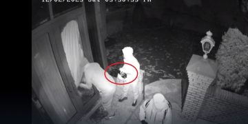 A still from a surveillance video shows a gang breaking into a home -- with one of the men holding a jammer.